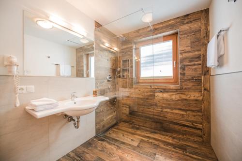 a bathroom with a sink and a shower with a window at Pichlerhof in Valle Di Casies