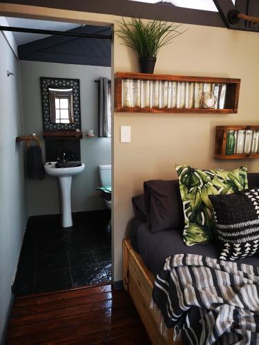 a bedroom with a bed and a sink in a room at Treur River Lodge in Moremela
