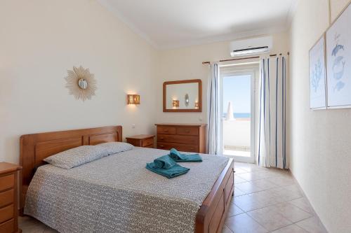 アルブフェイラにあるPé na Praiaのベッドルーム1室(青いタオル付きのベッド1台付)