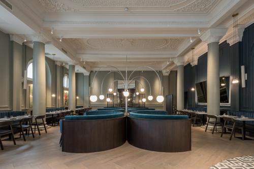 倫敦的住宿－The Clermont London, Victoria，一间配备有蓝色椅子和桌子的用餐室