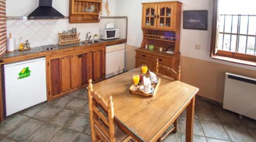 una cocina con una mesa de madera con bebidas. en Casa Rural El Molinero en Cabezas Altas