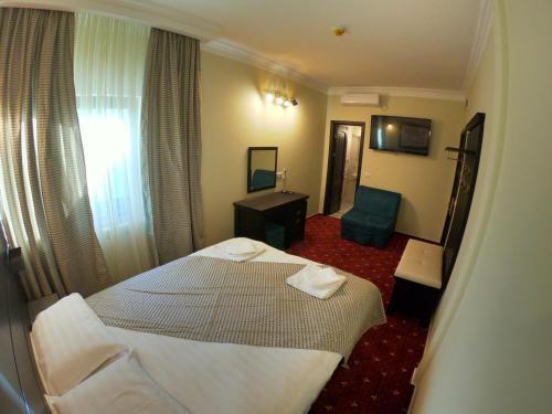 a hotel room with a bed and a chair at Casa Bucovineana in Suceava