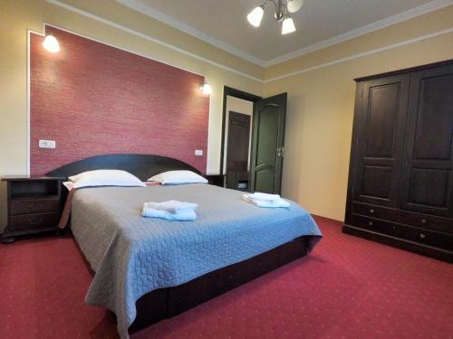 a bedroom with a large bed with towels on it at Casa Bucovineana in Suceava