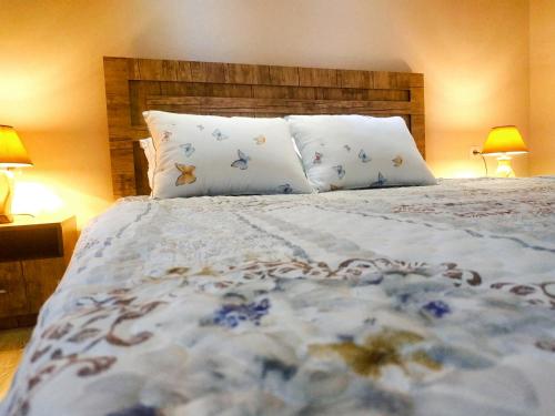 a bedroom with a large bed with two lamps at Happy House in Samarkand