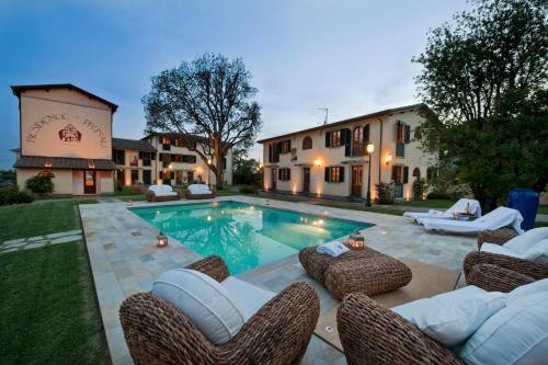 een achtertuin met een zwembad met stoelen en een huis bij Residence Prunali in Massarosa