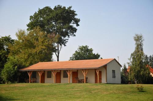 a white building with an orange roof on a field at Gergely Tanya in Garabonc