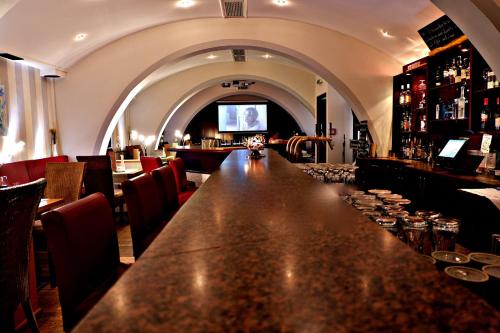 a bar with a long table in a restaurant at AktiVital Hotel in Bad Griesbach