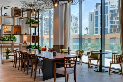 a dining room with a table and chairs and large windows at IntercityHotel Dubai Jaddaf Waterfront in Dubai