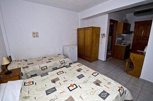 a bedroom with two beds and a kitchen at Mira Mare in Neo Klima