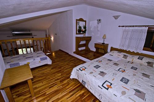 two beds in a bedroom with wooden floors at Mira Mare in Neo Klima