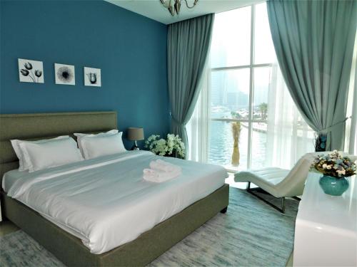 a bedroom with a large bed and a large window at Luton Vacation Homes - Continental, Dubai Marina in Dubai
