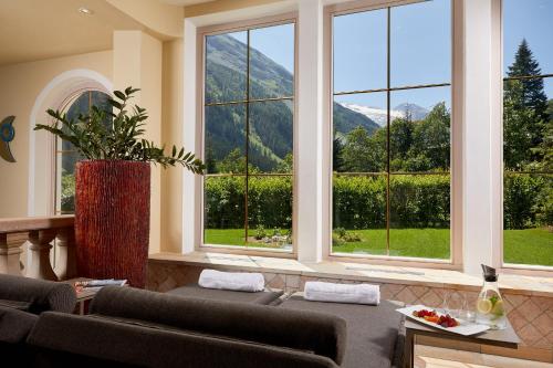a living room with two couches and a large window at Adler Inn Tyrol Mountain Resort SUPERIOR in Tux