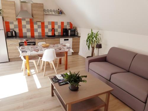 a living room with a couch and a table at Gite de Beg Menez Le 14 - Gite à la Forêt Fouesnant in La Forêt-Fouesnant
