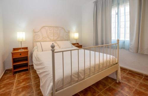 1 dormitorio con 1 cama, 2 lámparas y ventana en Villa Rosa, en Callao Salvaje