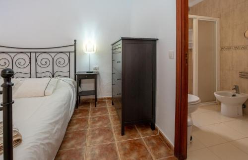 1 dormitorio con 1 cama y baño con aseo en Villa Rosa, en Callao Salvaje