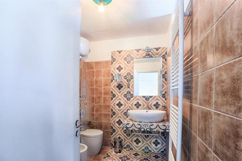 a bathroom with a sink and a toilet and a mirror at Tenuta Villa Colle Sereno in Montemarciano