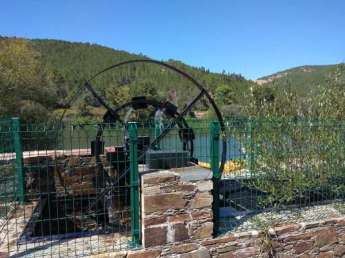 a gate with a roller coaster behind a fence at A casinha da Aldeia de Xisto in Fundão