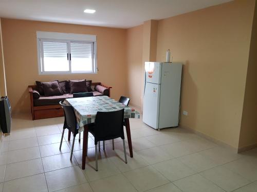 a living room with a table and a refrigerator at Departamenos Llanos in Termas de Río Hondo