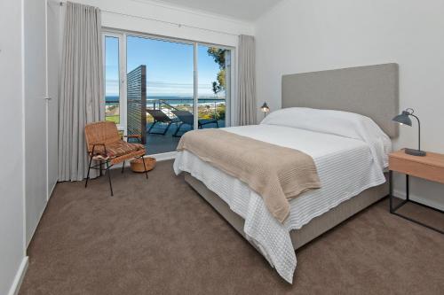a bedroom with a bed and a view of the ocean at Views Views Views in Hermanus