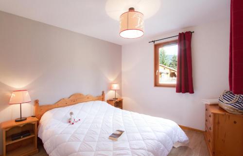 um quarto com uma cama branca e um urso de peluche em Résidence Odalys L'Orée des Pistes em Le Dévoluy