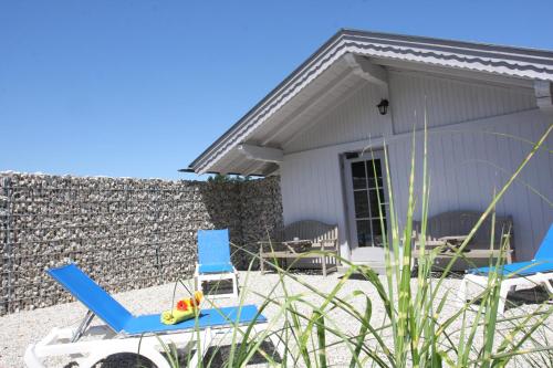a couple of blue chairs and a house at Farbinger Hof in Bernau am Chiemsee