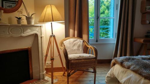 a room with a chair and a lamp and a window at La Closerie in Droue-sur-Drouette