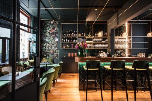 a restaurant with green chairs and a bar at Maison Margo in Ghent