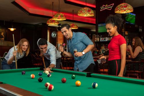 a group of people playing pool in a bar at Jumeira Rotana – Dubai in Dubai