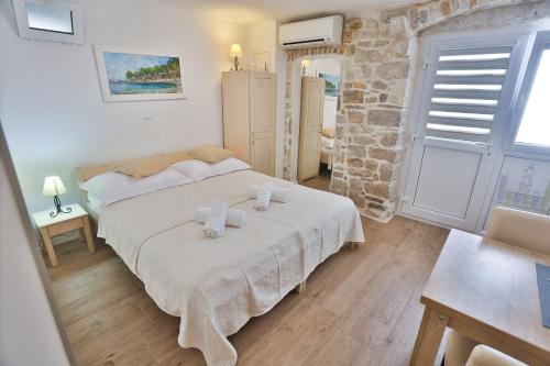 a bedroom with a bed and a stone wall at Split Inn Apartments in Split