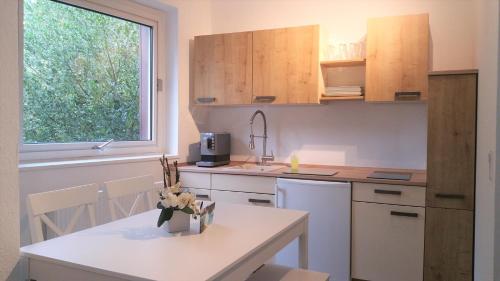 a kitchen with white cabinets and a table and a window at HOLI DAY SPA Appartement 1 in Berlin