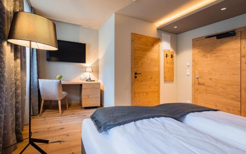 a bedroom with a bed with a lamp and a desk at Gasthof Furtner in Rohr im Gebirge