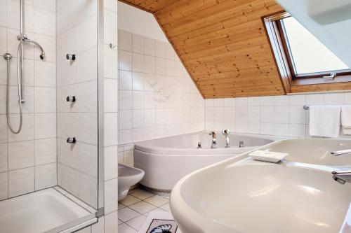 バート・クロツィンゲンにあるRegenbogen-Appartementのバスルーム(シャワー、バスタブ、シンク付)