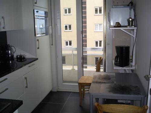 eine kleine Küche mit einem Tisch und einem Fenster in der Unterkunft residentie leopold app 21 in Blankenberge