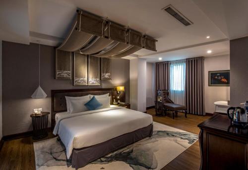 a bedroom with a large white bed in a room at The Odys Boutique Hotel in Ho Chi Minh City