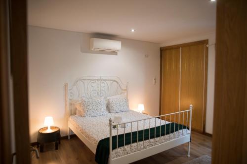 - une chambre avec un lit blanc et 2 lampes dans l'établissement CASA DA CASADA VILLA RURAL - FOZ DO DOURO by LW, à Foz do Sousa
