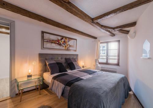 - une chambre avec un grand lit et une table dans l'établissement Le Carré d'or - Appartement avec vue Cathédrale, à Strasbourg