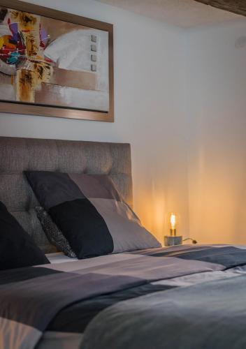 a bedroom with a bed with a picture on the wall at Le Carré d'or - Appartement avec vue Cathédrale in Strasbourg