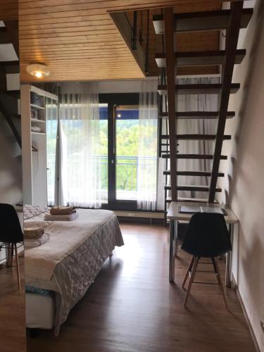 a bedroom with a bed and a spiral staircase at BaMeS BadUrach Metzingen Stuttgart in Bad Urach