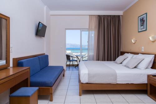 a hotel room with a bed and a blue couch at Sunny Bay Hotel in Kissamos
