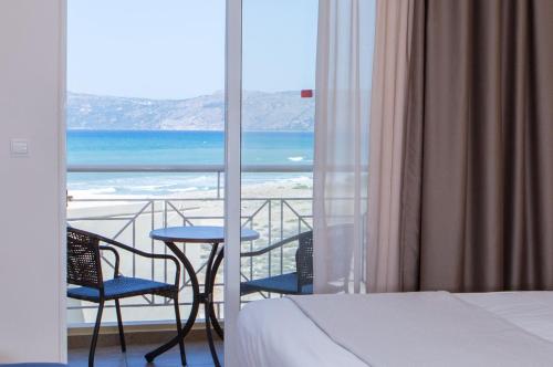 a bedroom with a bed and a view of the ocean at Sunny Bay Hotel in Kissamos