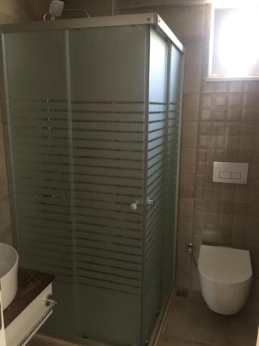 a bathroom with a toilet and a glass shower stall at Vespera hotel in Dalyan
