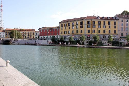a river in a city with buildings in the background at SAHI - Residenza Bianca di Savoia in Milan