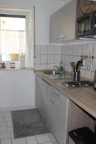 eine Küche mit einer Spüle und einer Arbeitsplatte in der Unterkunft Ferienwohnung Würzburg/Heidingsfeld in Würzburg