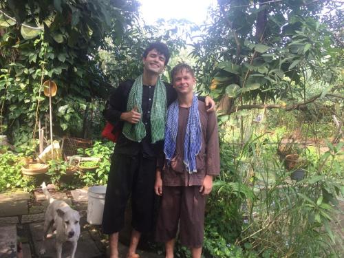 a man and a woman standing in a garden with a dog at Saigon Garden Homestay in Ho Chi Minh City