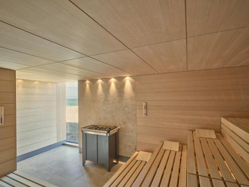 un sauna avec deux bancs et une cuisinière dans l'établissement Hotel de Blanke Top, à Cadzand-Bad