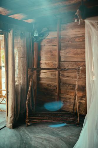 a room with a wooden wall and a swing at Whisky Point Resort in Arugam Bay