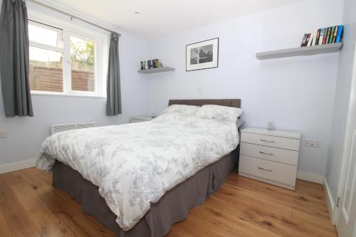 a bedroom with a bed and a dresser and a window at Beautiful Modern Apartment in Bath in Bath