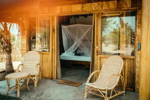 a room with two chairs and a bed in it at Whisky Point Resort in Arugam Bay