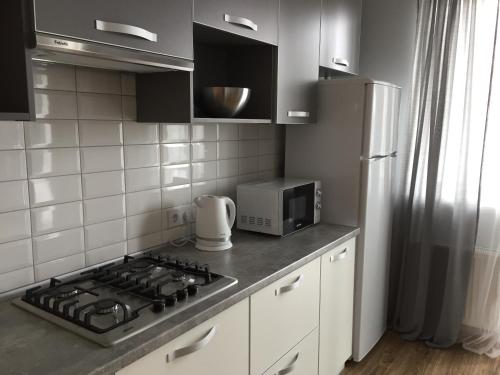 a kitchen with a stove top and a refrigerator at Scandinavian apartment in Lviv