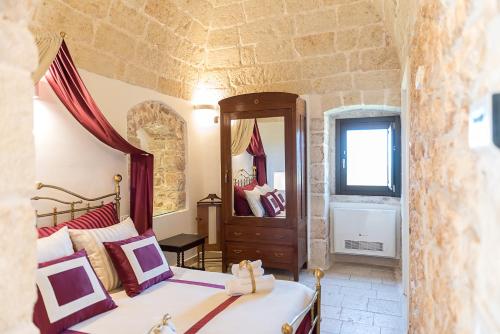 a bedroom with a bed and a mirror at Masseria Santo Stefano Relais&Charming House in Conversano